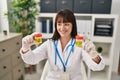 Young beautiful hispanic woman doctor comparing urine test tubes at clinic Royalty Free Stock Photo