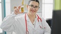 Young beautiful hispanic woman doctor holding bottle of pills at the clinic Royalty Free Stock Photo