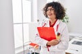 Young beautiful hispanic woman doctor smiling confident holding clipboard at clinic Royalty Free Stock Photo