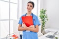 Young beautiful hispanic woman doctor smiling confident holding clipboard at clinic Royalty Free Stock Photo