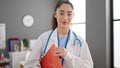 Young beautiful hispanic woman doctor smiling confident holding medical report at clinic Royalty Free Stock Photo