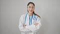 Young beautiful hispanic woman doctor smiling confident standing with arms crossed gesture over isolated white background Royalty Free Stock Photo