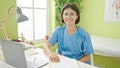 Young beautiful hispanic woman doctor smiling confident wearing glasses at clinic Royalty Free Stock Photo