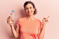 Young beautiful hispanic woman drinking bottle of water smiling happy pointing with hand and finger to the side Royalty Free Stock Photo