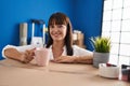 Young beautiful hispanic woman drinking coffee leaning on package at new home Royalty Free Stock Photo