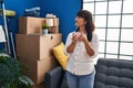 Young beautiful hispanic woman drinking coffee standing at new home Royalty Free Stock Photo