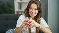 Young beautiful hispanic woman drinking tea sitting on sofa at home Royalty Free Stock Photo