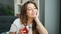 Young beautiful hispanic woman drinking tea sitting on sofa thinking at home Royalty Free Stock Photo