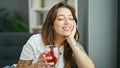 Young beautiful hispanic woman drinking tea sitting on sofa thinking at home Royalty Free Stock Photo