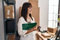 Young beautiful hispanic woman ecommerce business worker holding clipboard at office Royalty Free Stock Photo