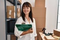Young beautiful hispanic woman ecommerce business worker holding clipboard at office Royalty Free Stock Photo
