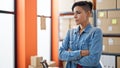 Young beautiful hispanic woman ecommerce business worker standing with arms crossed gesture at office Royalty Free Stock Photo