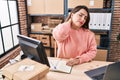 Young beautiful hispanic woman ecommerce business worker suffering for neck ache at office Royalty Free Stock Photo