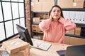 Young beautiful hispanic woman ecommerce business worker suffering for neck ache at office Royalty Free Stock Photo