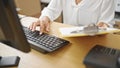 Young beautiful hispanic woman ecommerce business worker using computer holding clipboard at office Royalty Free Stock Photo