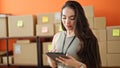 Young beautiful hispanic woman ecommerce business worker using touchpad with serious face at office Royalty Free Stock Photo