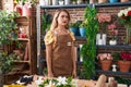 Young beautiful hispanic woman florist standing with serious expression at flower shop Royalty Free Stock Photo