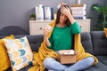 Young beautiful hispanic woman holding pills of delivery package sitting on sofa at home Royalty Free Stock Photo