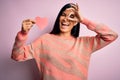 Young beautiful hispanic woman holding romantic heart paper shape over pink background with happy face smiling doing ok sign with Royalty Free Stock Photo
