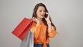 Young beautiful hispanic woman holding shopping bags talking on smartphone over isolated white background Royalty Free Stock Photo