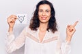 Young beautiful hispanic woman holding transgender symbol reminder smiling happy pointing with hand and finger to the side