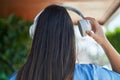 Young beautiful hispanic woman listening to music on back view at street Royalty Free Stock Photo