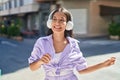 Young beautiful hispanic woman listening to music and dancing at street Royalty Free Stock Photo