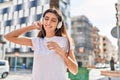 Young beautiful hispanic woman listening to music and dancing at street Royalty Free Stock Photo