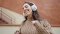 Young beautiful hispanic woman listening to music and dancing at street Royalty Free Stock Photo