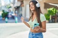 Young beautiful hispanic woman listening to music and dancing at street Royalty Free Stock Photo