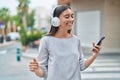 Young beautiful hispanic woman listening to music and dancing at street Royalty Free Stock Photo