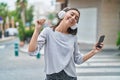 Young beautiful hispanic woman listening to music and dancing at street Royalty Free Stock Photo