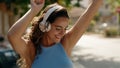 Young beautiful hispanic woman listening to music and dancing at street Royalty Free Stock Photo