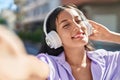 Young beautiful hispanic woman listening to music make selfie by camera at street Royalty Free Stock Photo