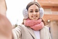 Young beautiful hispanic woman make selfie by camera wearing scarf and earmuff at street Royalty Free Stock Photo