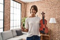 Young beautiful hispanic woman musician smiling confident holding violin at home Royalty Free Stock Photo