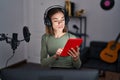 Young beautiful hispanic woman musician using touchpad at music studio