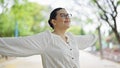 Young beautiful hispanic woman with open arms at the park Royalty Free Stock Photo