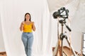 Young beautiful hispanic woman posing as model at photography studio excited for success with arms raised and eyes closed Royalty Free Stock Photo