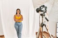 Young beautiful hispanic woman posing as model at photography studio happy face smiling with crossed arms looking at the camera Royalty Free Stock Photo
