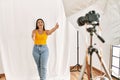 Young beautiful hispanic woman posing as model at photography studio looking at the camera smiling with open arms for hug Royalty Free Stock Photo