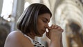 Young beautiful hispanic woman praying at Augustinian Church in Vienna Royalty Free Stock Photo