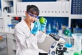 Young beautiful hispanic woman scientist holding pepper measuring liquid at laboratory Royalty Free Stock Photo