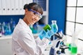 Young beautiful hispanic woman scientist holding pepper measuring liquid at laboratory