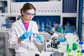 Young beautiful hispanic woman scientist holding pill at laboratory Royalty Free Stock Photo