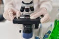 Young beautiful hispanic woman scientist looking sample on microscope at laboratory Royalty Free Stock Photo