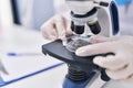 Young beautiful hispanic woman scientist looking sample using microscope at laboratory Royalty Free Stock Photo