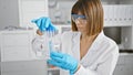 Young beautiful hispanic woman scientist looking at test tubes at laboratory Royalty Free Stock Photo