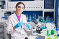 Young beautiful hispanic woman scientist smiling confident holding pill at laboratory Royalty Free Stock Photo