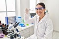 Young beautiful hispanic woman scientist smiling confident holding pill at laboratory Royalty Free Stock Photo